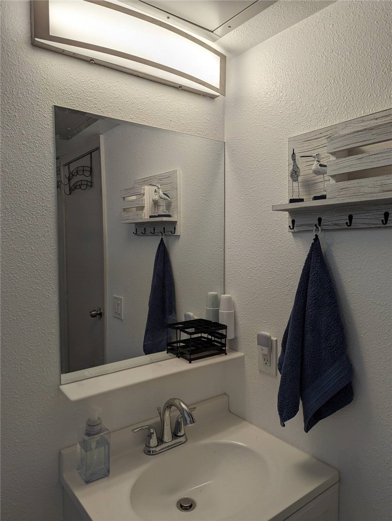 3938 Surfside Boulevard, Unit 3129 Corpus Christi, TX 78402 - Photo 19 of 39 a bathroom with a sink and a mirror