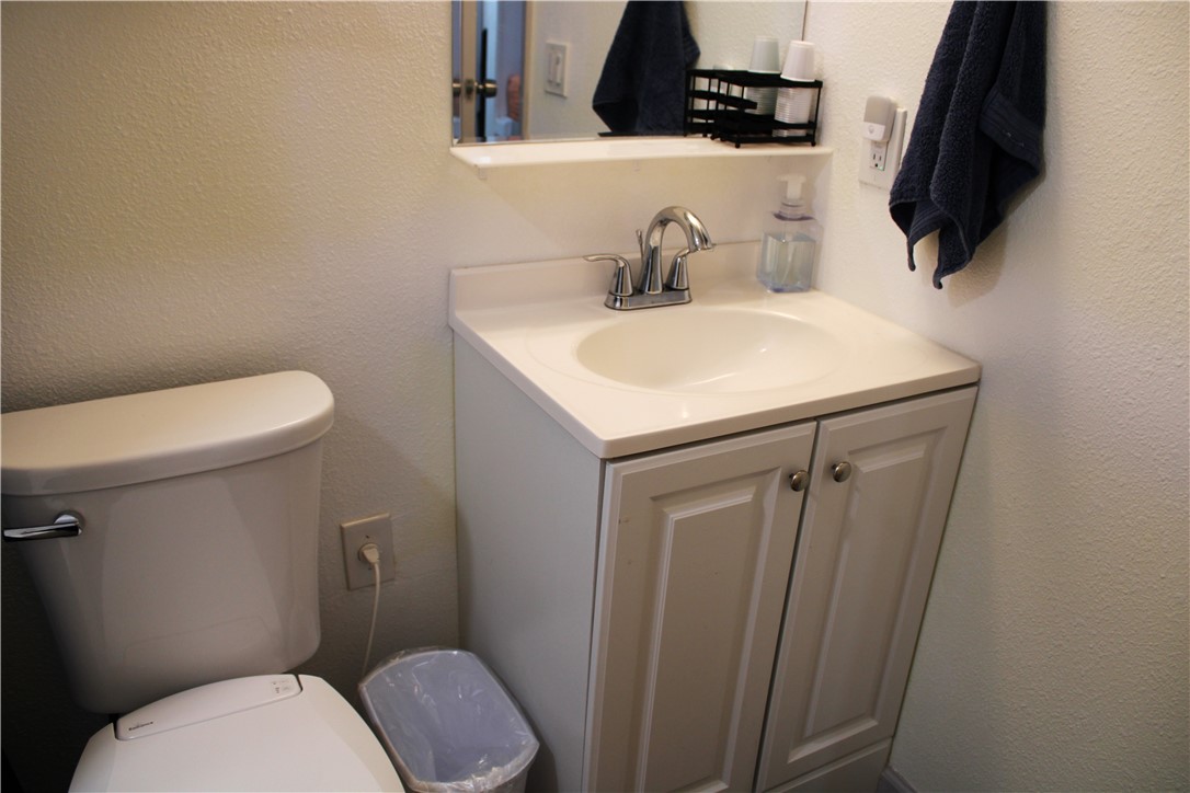 3938 Surfside Boulevard, Unit 3129 Corpus Christi, TX 78402 - Photo 21 of 39 a bathroom with a toilet a sink and mirror