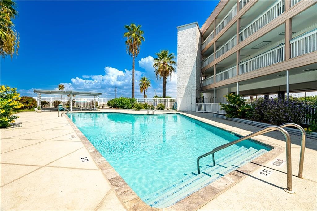 3938 Surfside Boulevard, Unit 3129 Corpus Christi, TX 78402 - Photo 28 of 39 a swimming pool with outdoor seating and yard