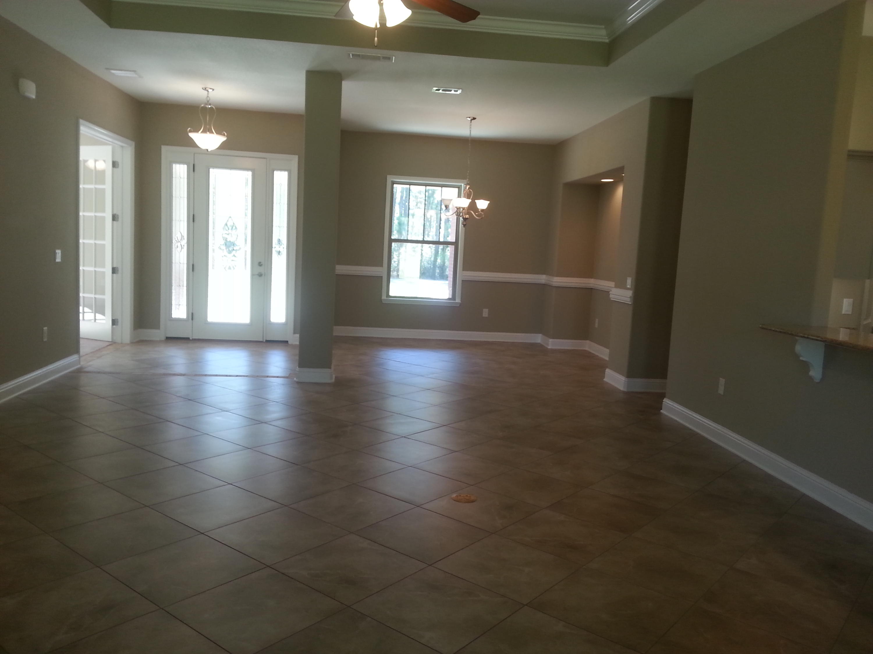 2442 Cove Road Navarre, FL 32566 - Photo 8 of 23 an empty room with wooden floor and windows