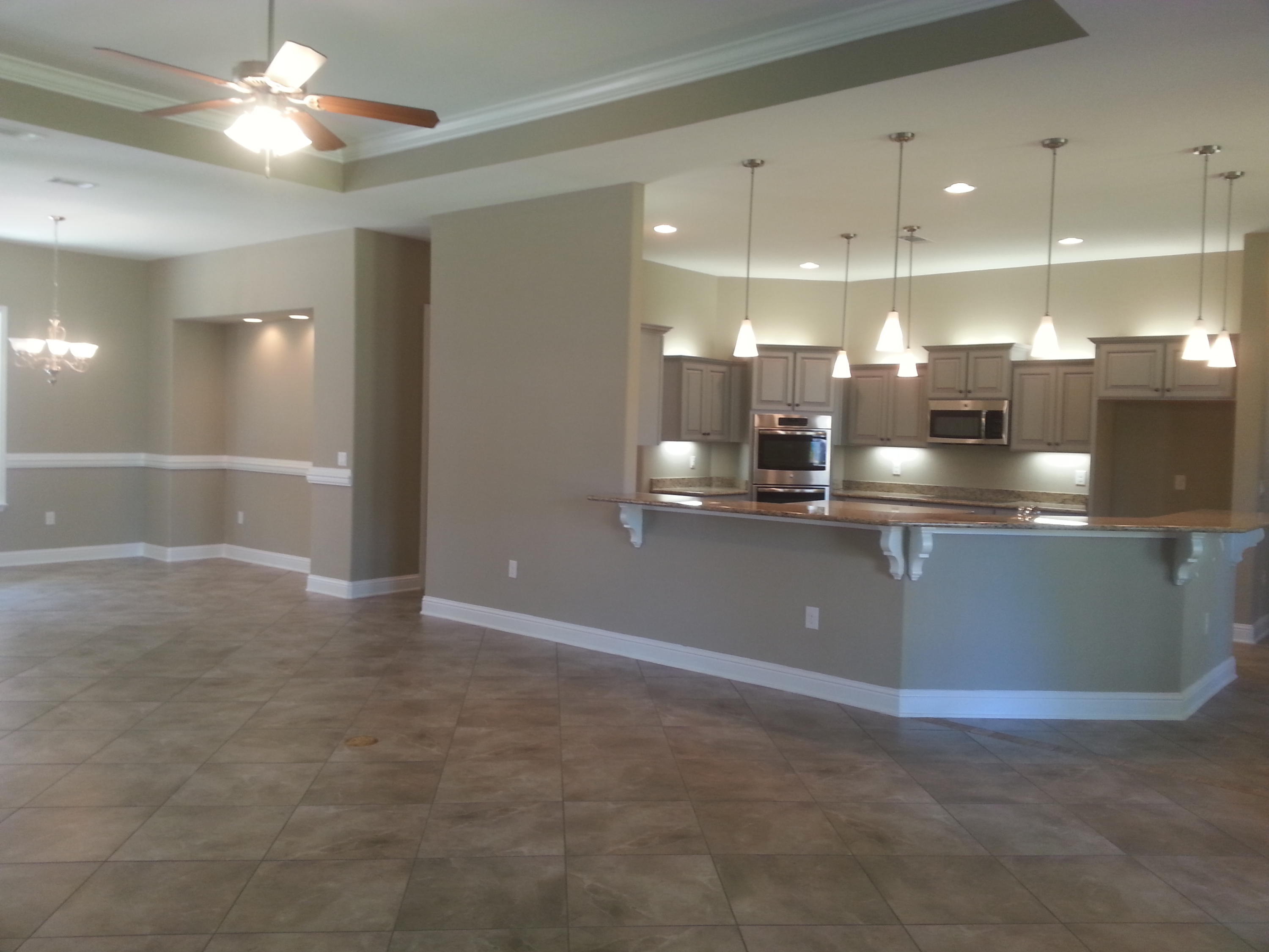 2442 Cove Road Navarre, FL 32566 - Photo 9 of 23 a kitchen with kitchen island a sink and a stove top oven