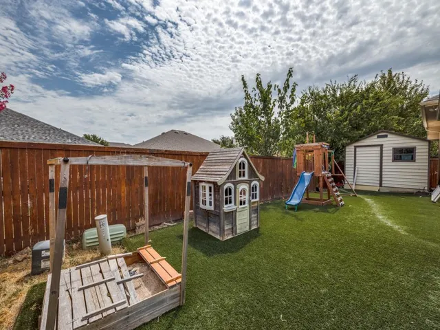 a view of a chairs and table in the backyard