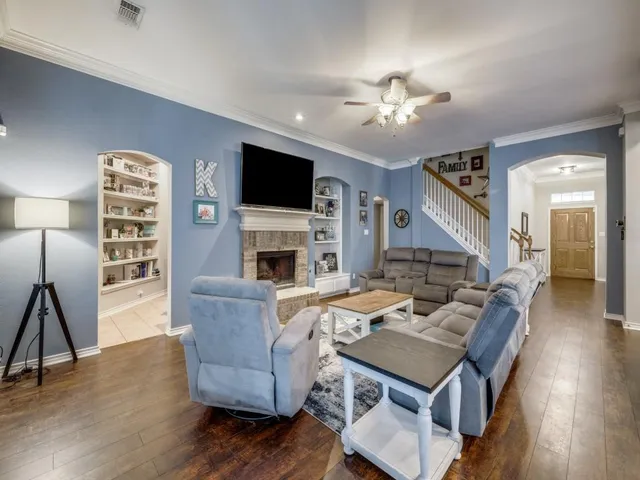 a living room with furniture a fireplace and a flat screen tv