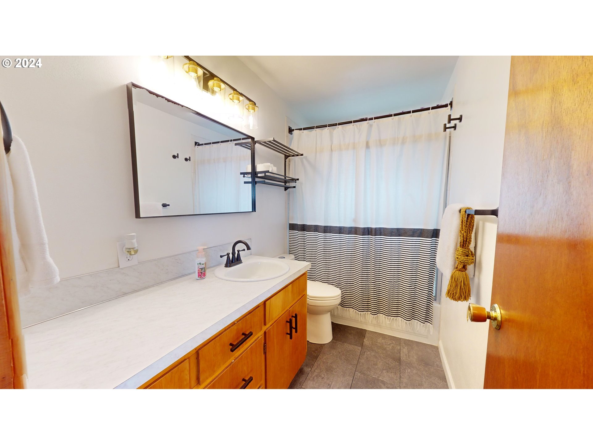 4675 Daisy Street Springfield, OR 97478 - Photo 15 of 43 a bathroom with a sink a mirror and a shower