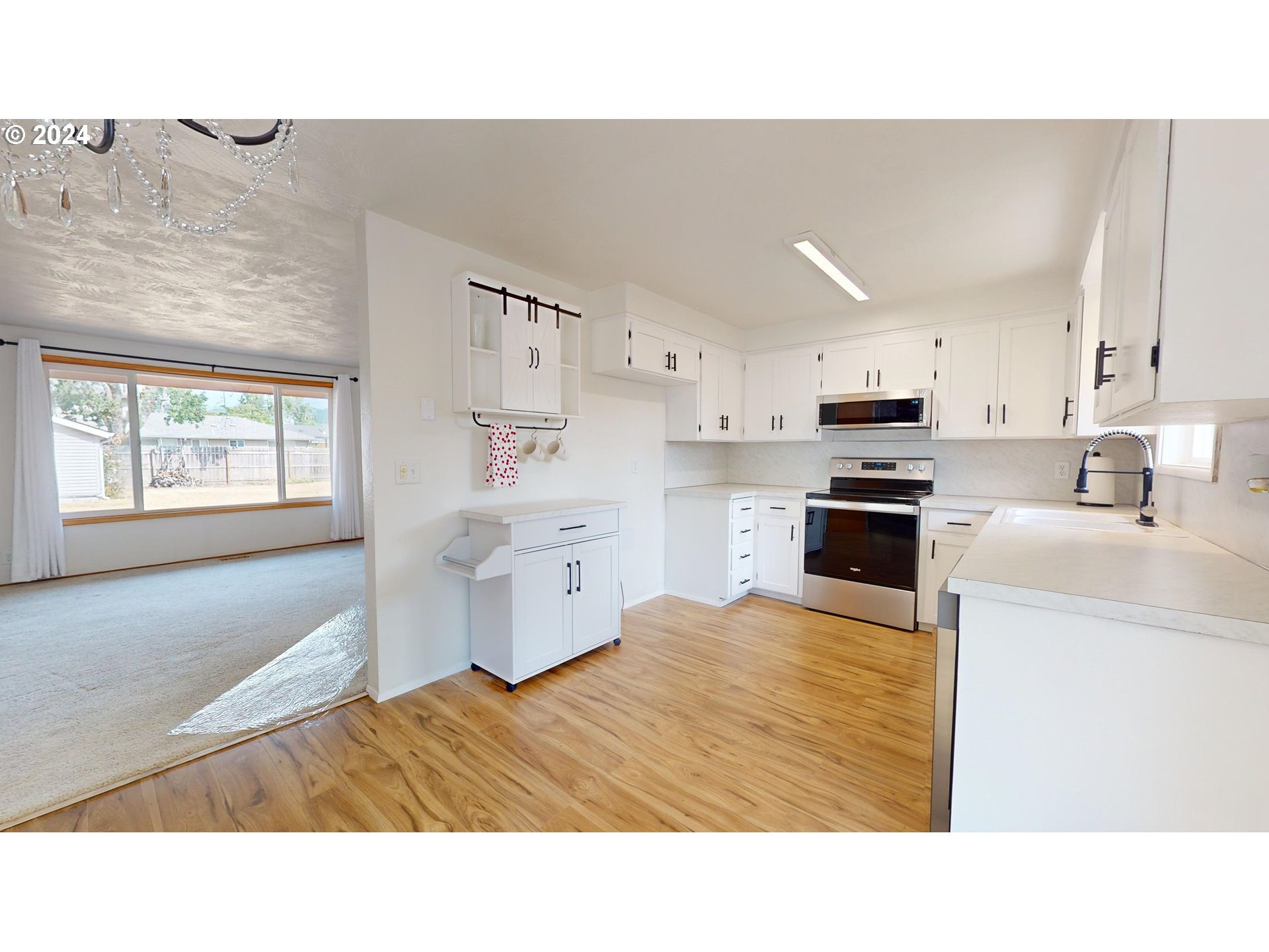 4675 Daisy Street Springfield, OR 97478 - Photo 6 of 43 a kitchen with kitchen island white cabinets and stainless steel appliances