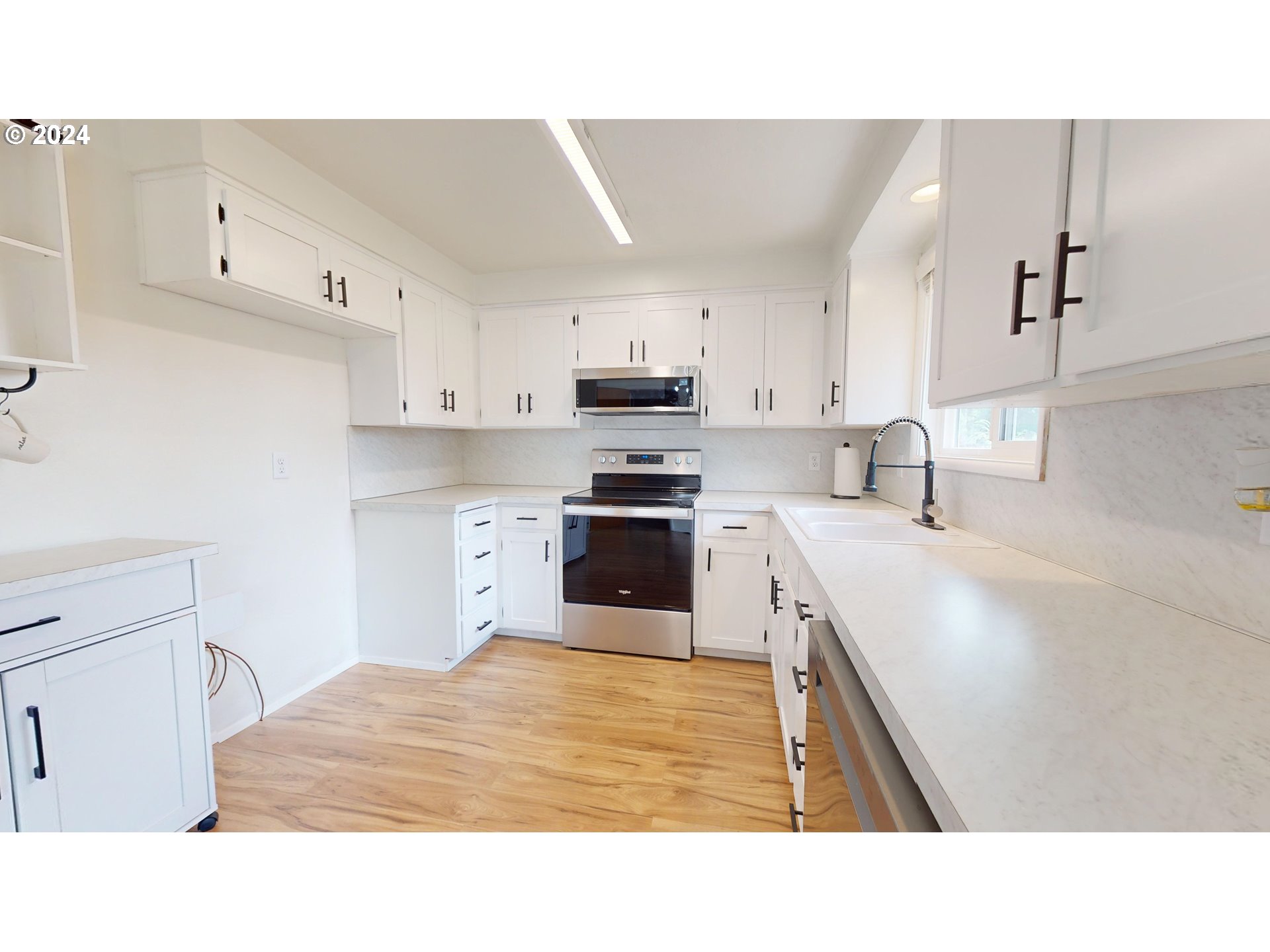 4675 Daisy Street Springfield, OR 97478 - Photo 7 of 43 a kitchen with kitchen island a stove a sink and a refrigerator