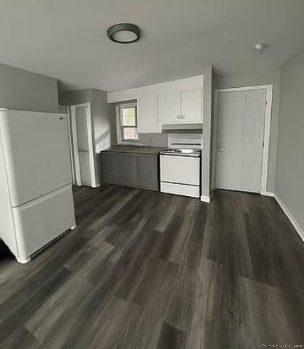 a kitchen with a refrigerator and a stove top oven