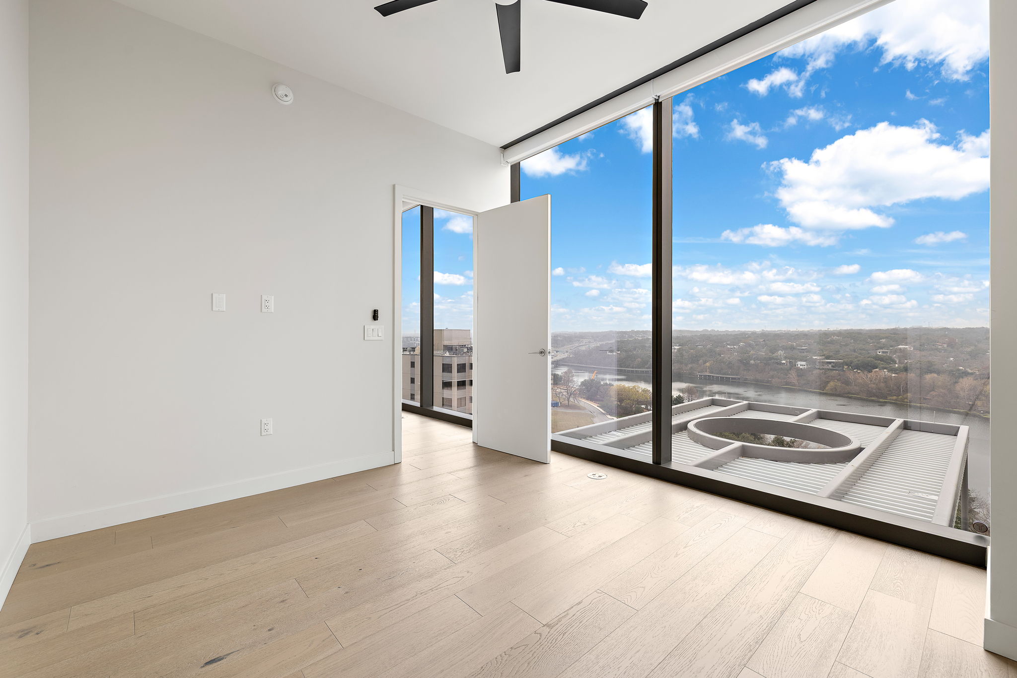 44 East Avenue, Unit 1210 Austin, TX 78701 - Photo 8 of 40 Spare room featuring floor to ceiling windows, light wood finished floors, and a ceiling fan