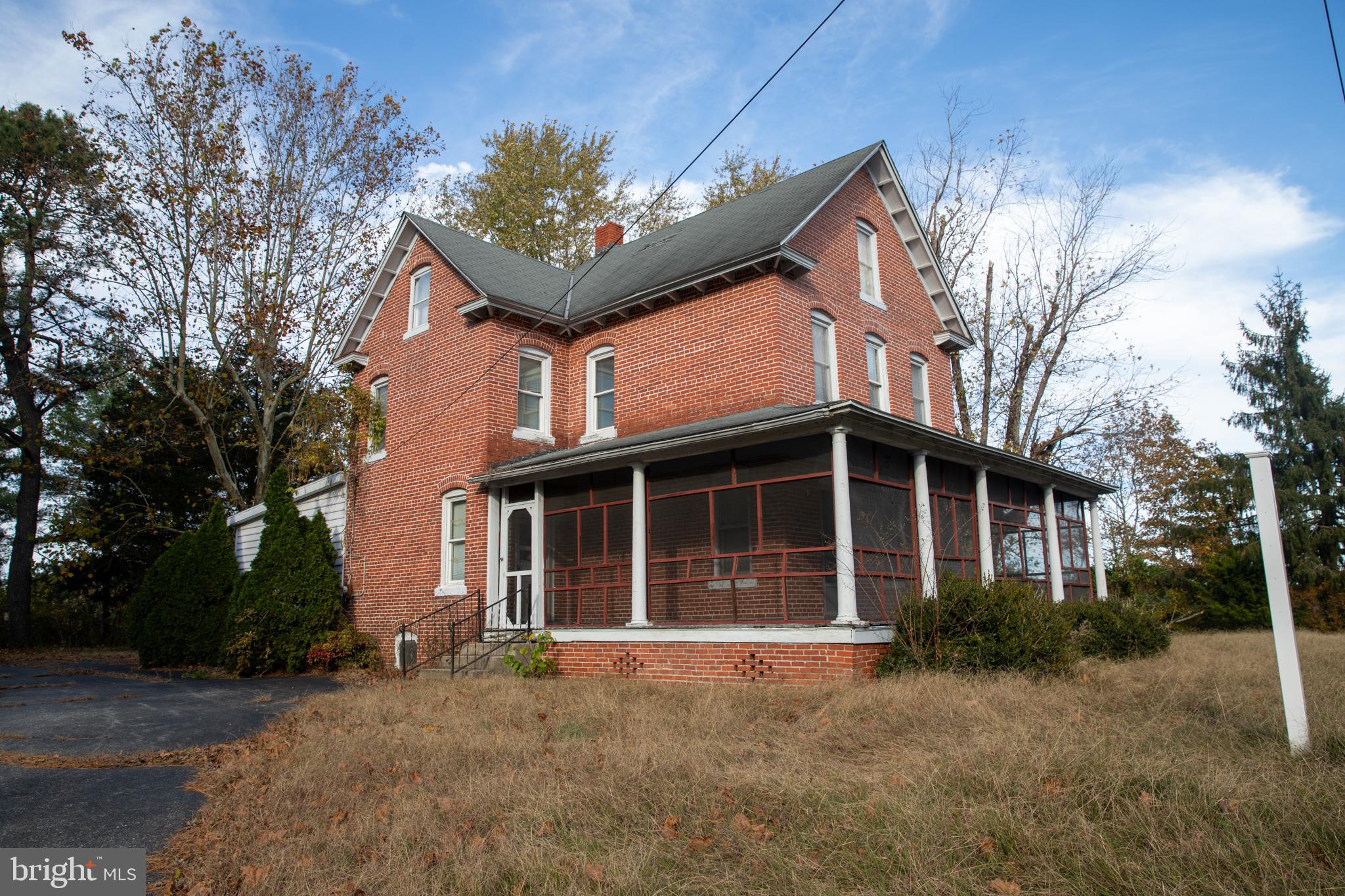 a view of a house with a yard and large tree
