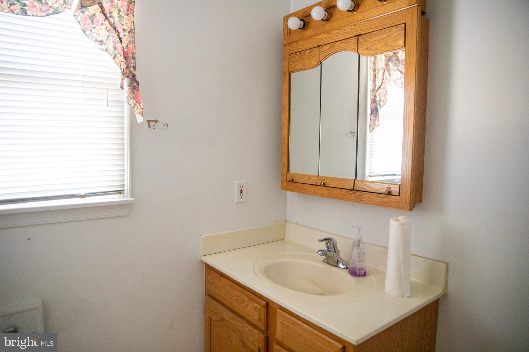 26121 Lewes Georgetown Highway Georgetown, DE 19947 - Photo 39 of 72 a bathroom with a sink a vanity and a mirror