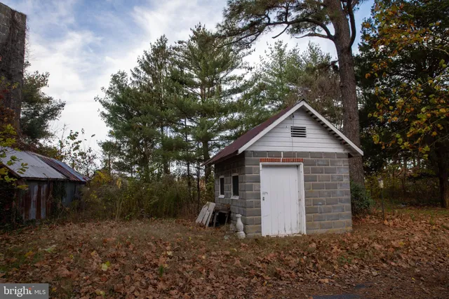 a front view of a house with a yard and large trees
