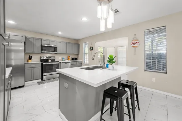 a kitchen with kitchen island a counter top space appliances and cabinets