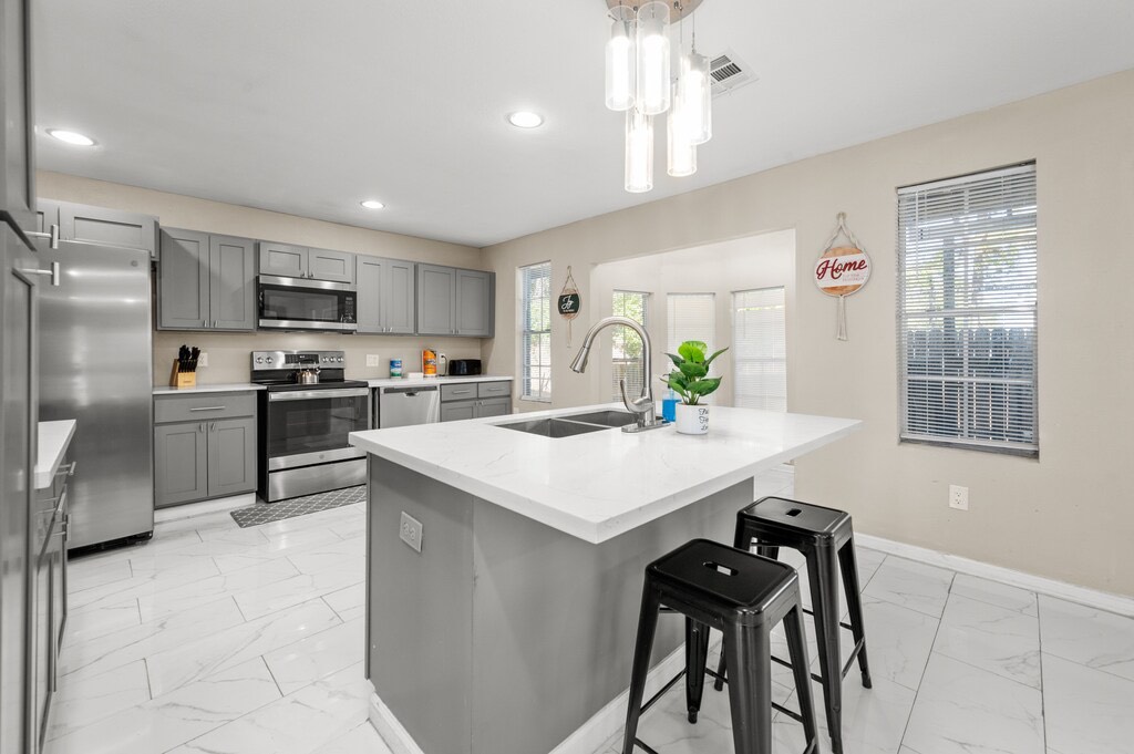 a kitchen with kitchen island a counter top space appliances and cabinets