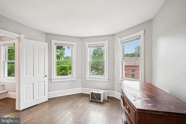 a view of an empty room with wooden floor