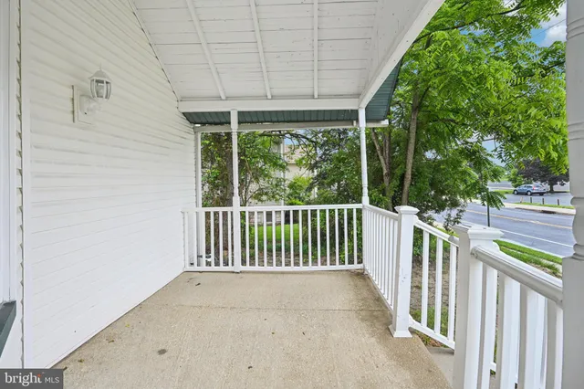 an empty room with wooden floor fireplace and windows