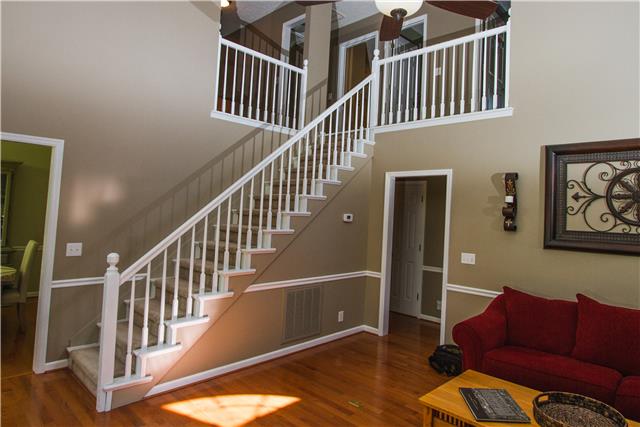 4155 Bethlehem Road Springfield, TN 37172 - Photo 5 of 19 Walk through the front door into the brilliant living room that comes to life with all the natural sunlight. Real wood floors and a floor-to-ceiling brick fireplace. Perfect for entertaining! The first of 2 staircases leading to the second story.