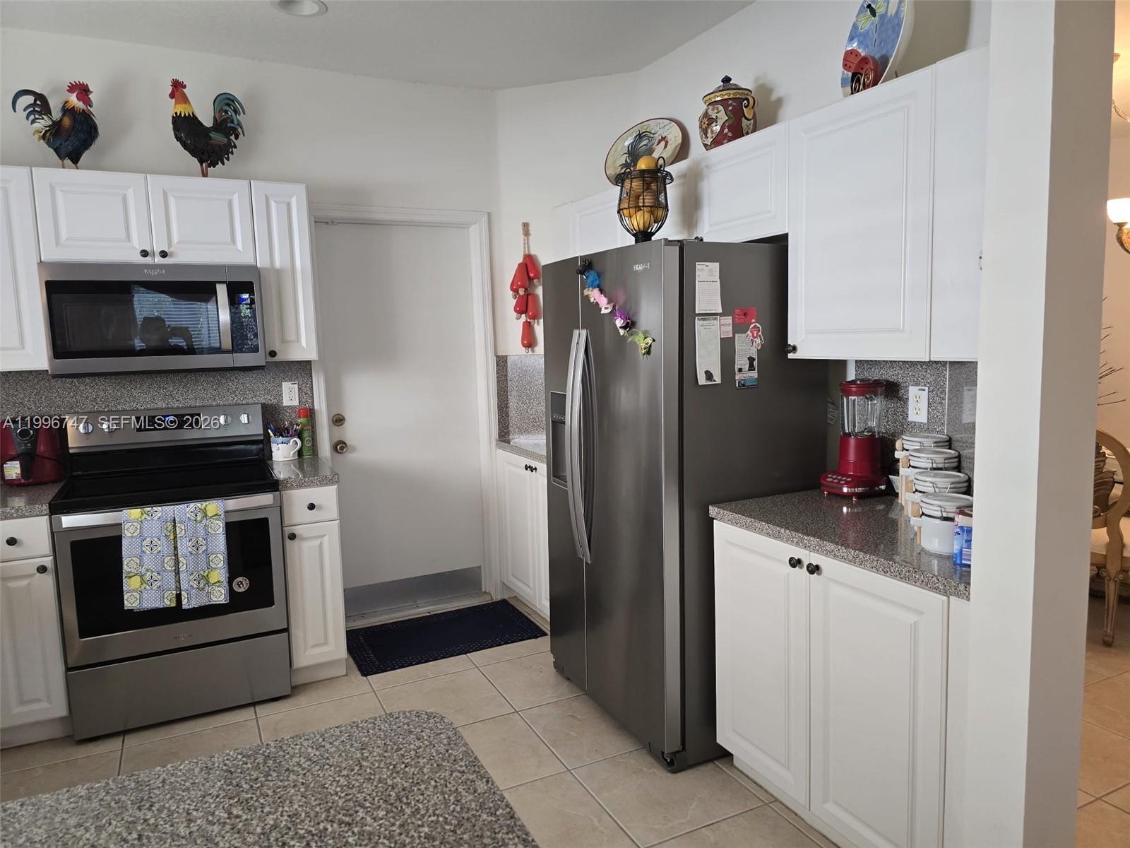 13016 Southwest 142nd Terrace Miami, FL 33186 - Photo 11 of 67 a kitchen with white cabinets and refrigerator