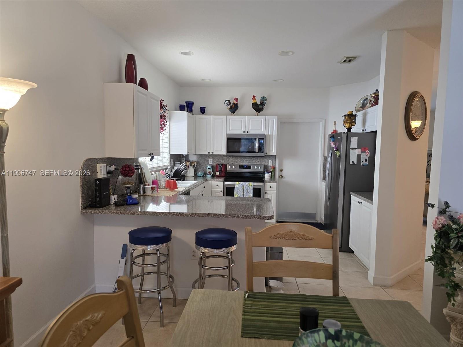 13016 Southwest 142nd Terrace Miami, FL 33186 - Photo 37 of 67 a kitchen with granite countertop cabinets and refrigerator