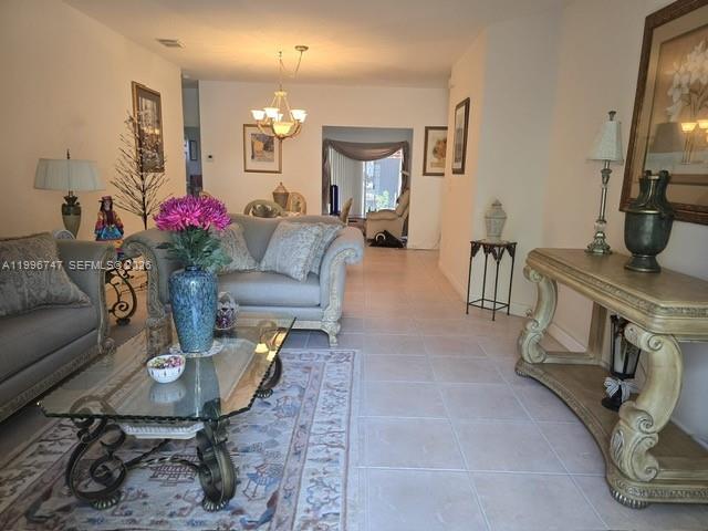 13016 Southwest 142nd Terrace Miami, FL 33186 - Photo 4 of 67 a living room with furniture and a chandelier
