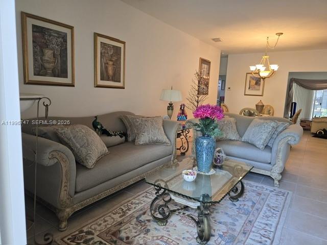 13016 Southwest 142nd Terrace Miami, FL 33186 - Photo 52 of 67 a living room with furniture and a chandelier