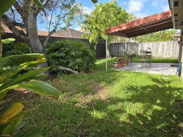 13016 Southwest 142nd Terrace Miami, FL 33186 - Photo 55 of 67 a view of a backyard with table and chairs under an umbrella with a small yard