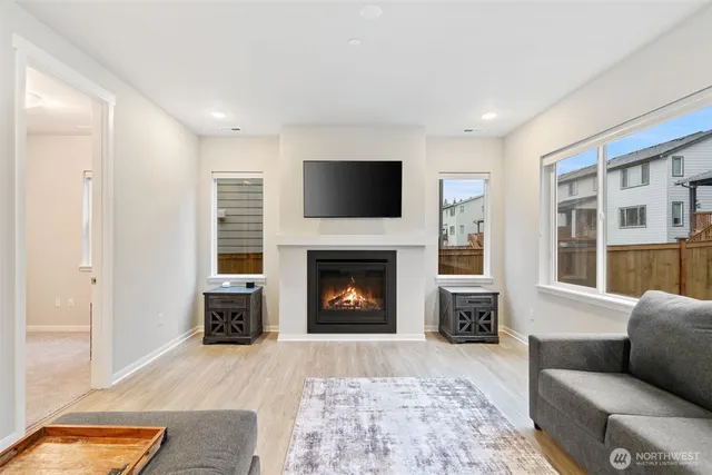 a living room with furniture a flat screen tv and a fireplace
