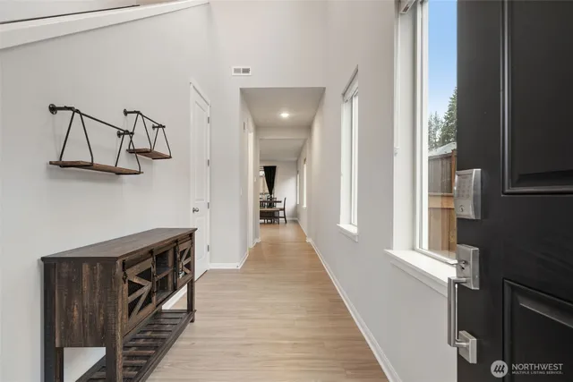 a view of a hallway with wooden floor and staircase
