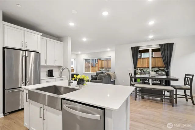 a kitchen with a sink a stove a refrigerator and chairs