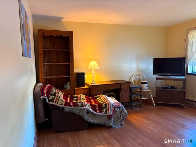 a bedroom with furniture and wooden floor