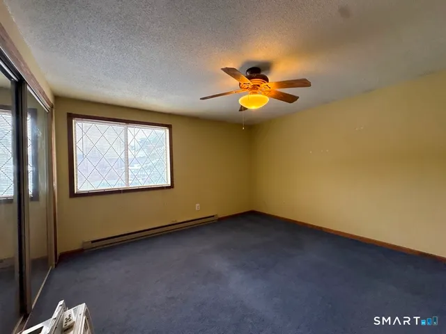 an empty room with a window and ceiling fan