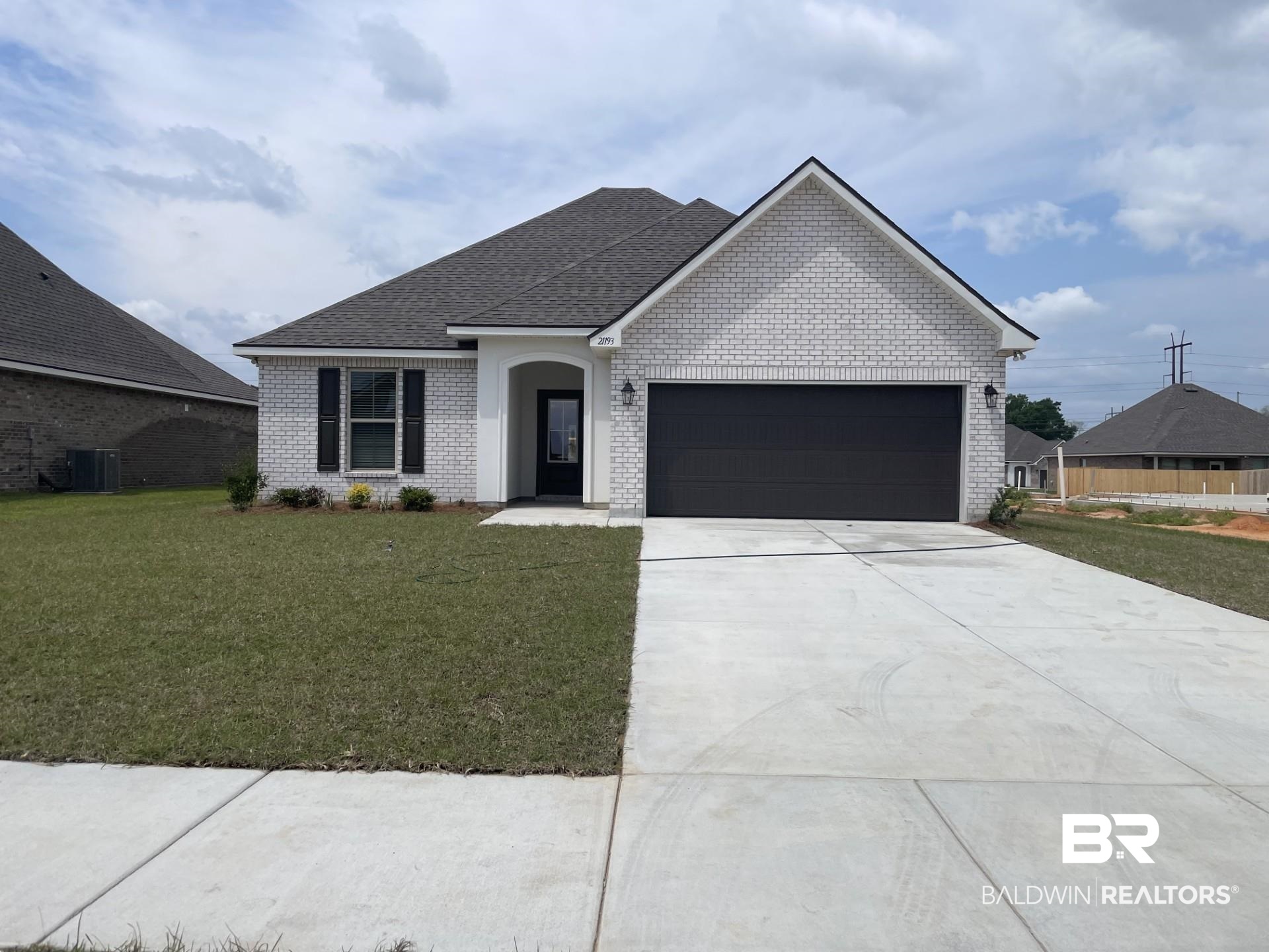 Ranch-style home with cooling unit, a front lawn, brick siding, a garage, and concrete driveway