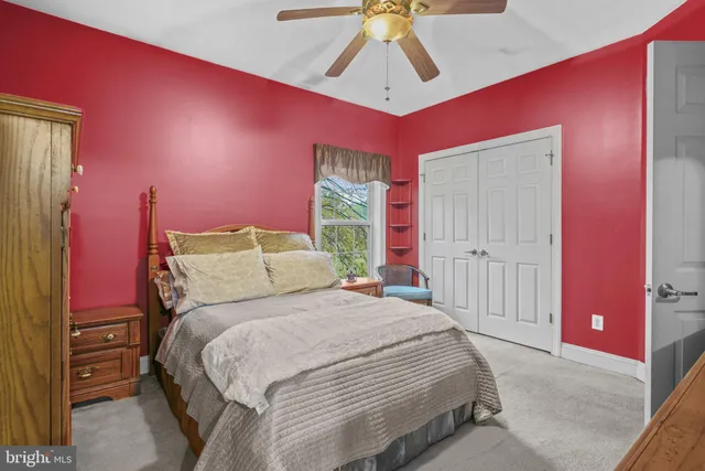 a bedroom with a bed chandelier and a window