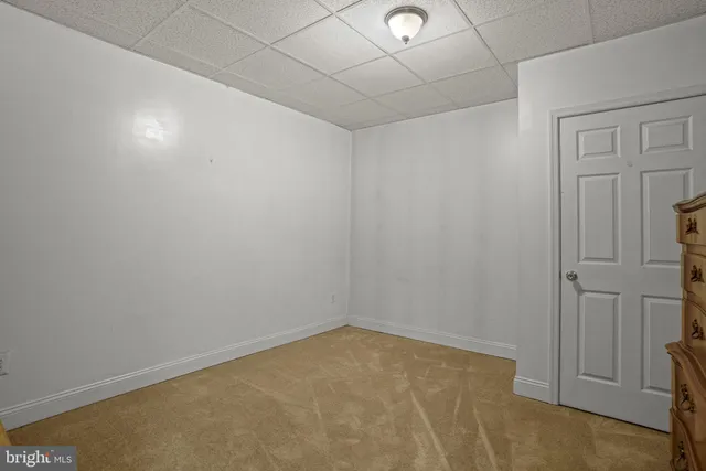 a bedroom with bed and paintings on the wall