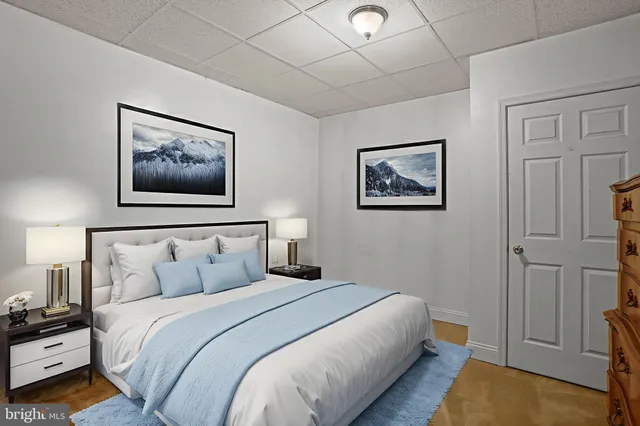 a bedroom with a bed a couch and a flat screen tv