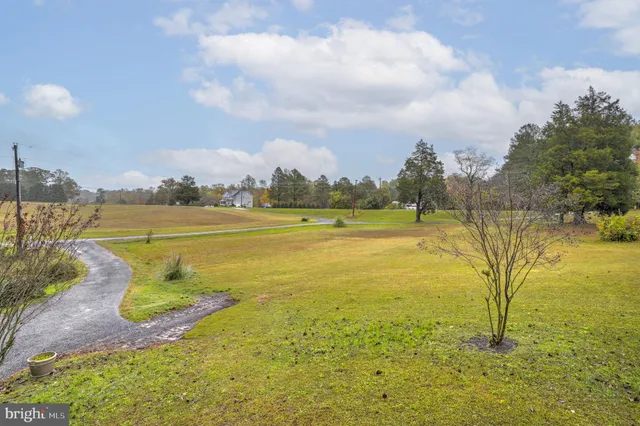 a backyard of a house with lots of green space and fountain
