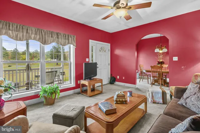 a living room with furniture a chandelier and a floor to ceiling window