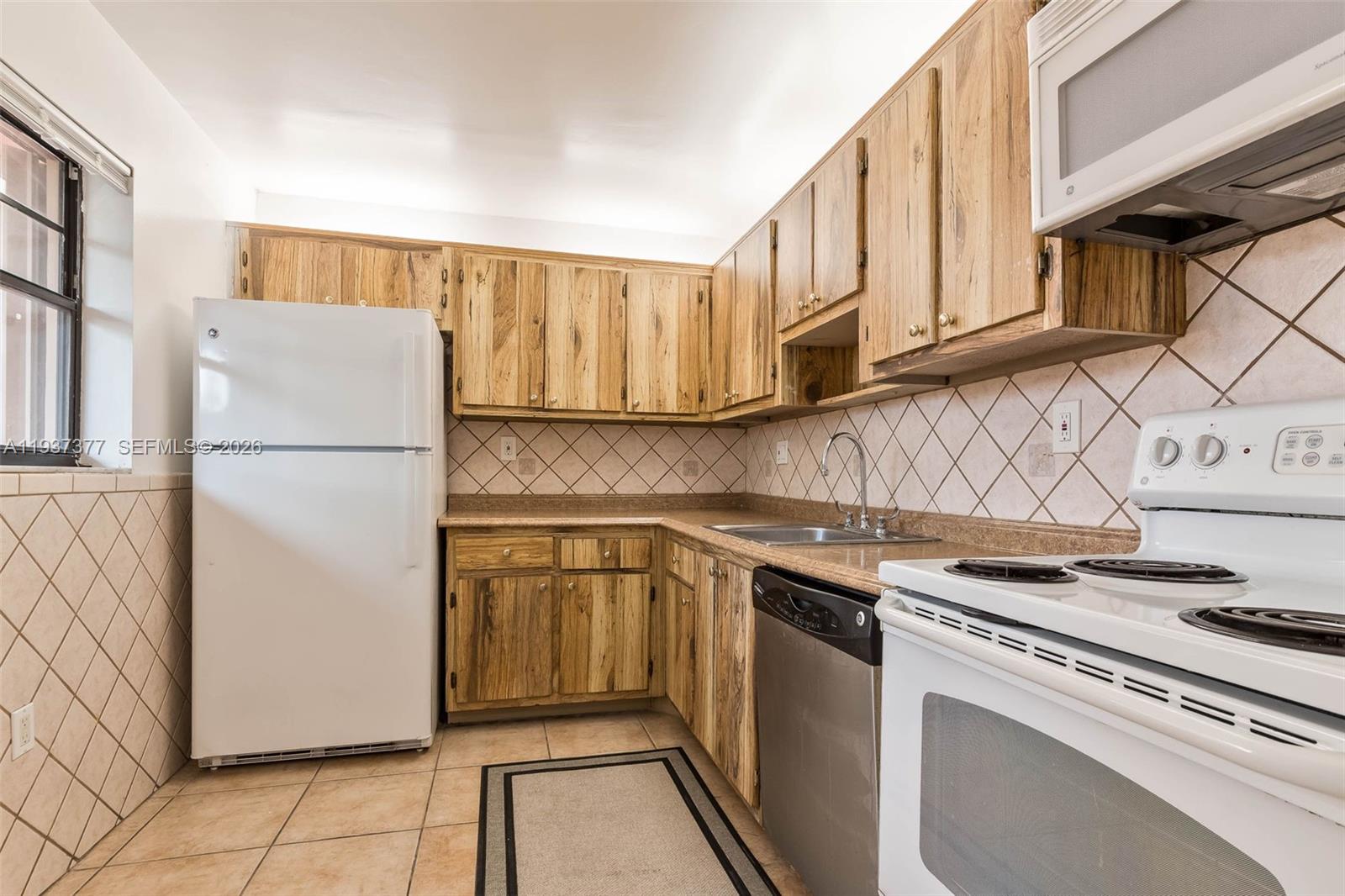10985 Southwest 107th Street, Unit 310 Miami, FL 33176 - Photo 5 of 30 a kitchen with stainless steel appliances granite countertop a refrigerator sink and cabinets