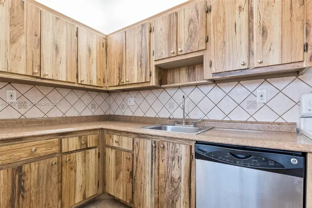 a view of a kitchen with wooden cabinets