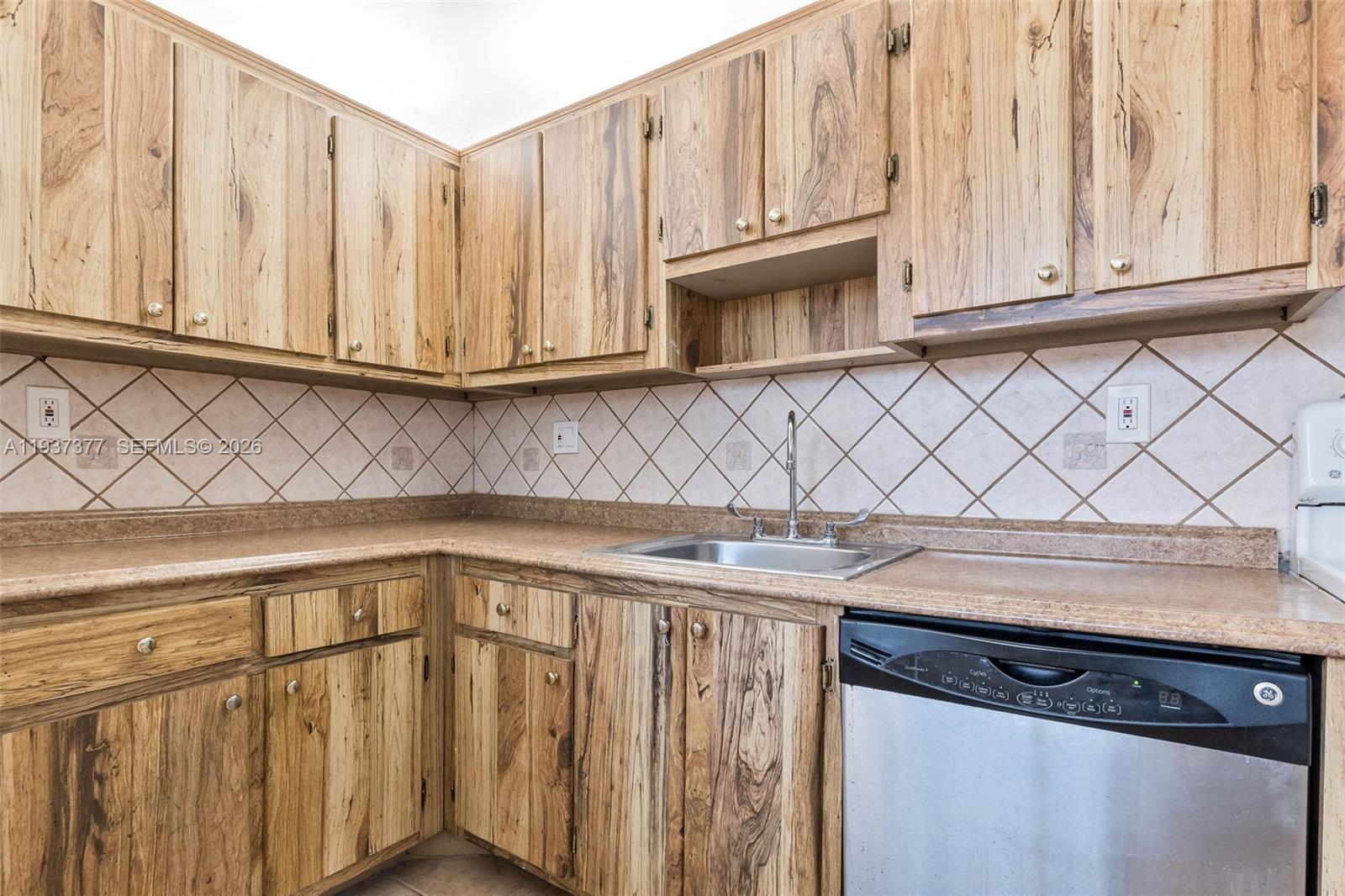 10985 Southwest 107th Street, Unit 310 Miami, FL 33176 - Photo 6 of 30 a view of a kitchen with wooden cabinets