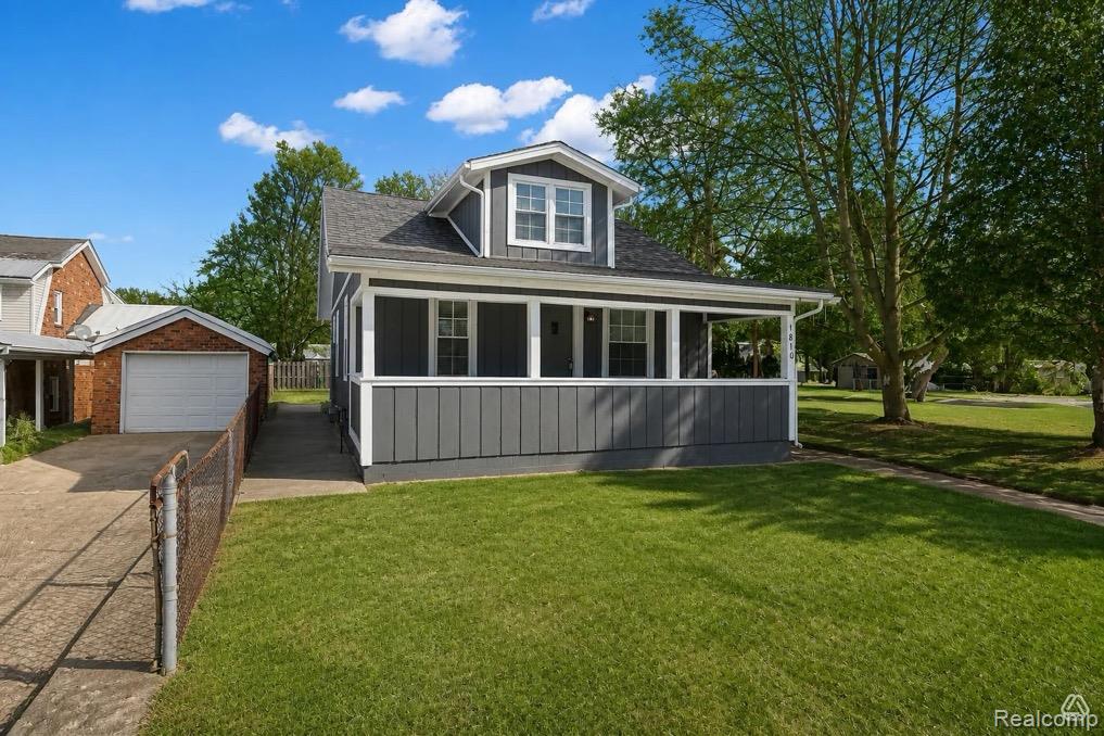 1810 Manse Road Waterford, MI 48328 - Photo 2 of 34 Gray siding exterior with white trim, covered front porch, dormer window, attached single-car garage, and a concrete driveway