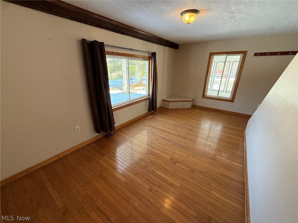 6784 Old Zoarville Road Northeast Dover, OH 44622 - Photo 6 of 50 Unfurnished room with light wood-style flooring and a textured ceiling