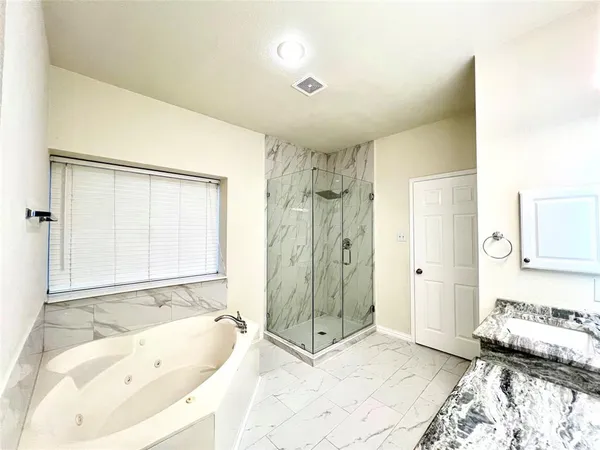 a bathroom with a tub shower and sink