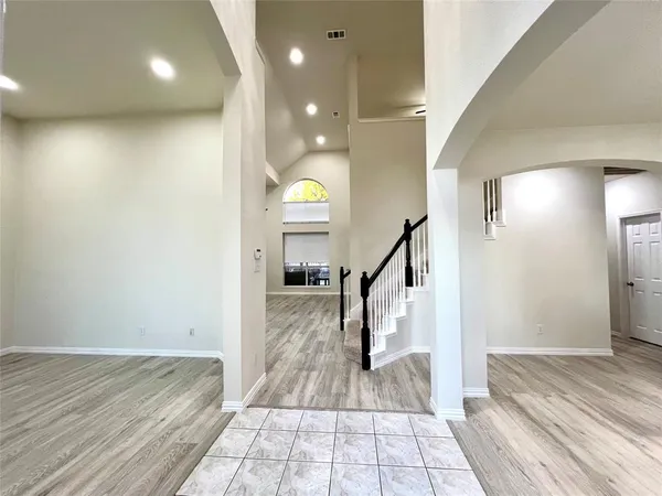 a view of a hallway view with staircase and a living room