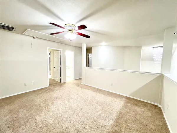 an empty room with a ceiling fan and a window