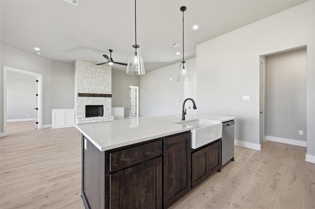108 Rocky Top Azle, TX 76020 - Photo 9 of 40 a kitchen with a sink a chandelier stainless steel appliances and cabinets