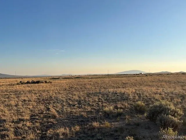 an aerial view of house with yard and mountain view in back
