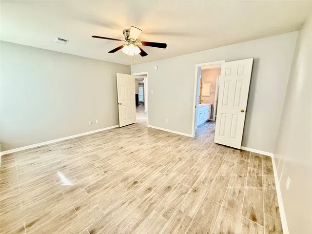 a view of an empty room with wooden floor