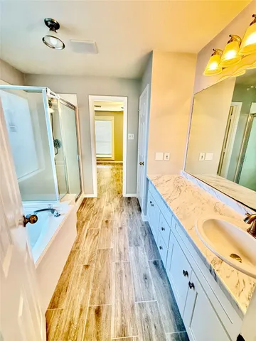a spacious bathroom with a granite countertop tub sink and a mirror