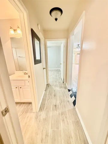 a view of a hallway with wooden floor and staircase