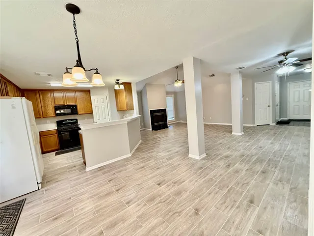 a view of a kitchen with wooden floor and electronic appliances